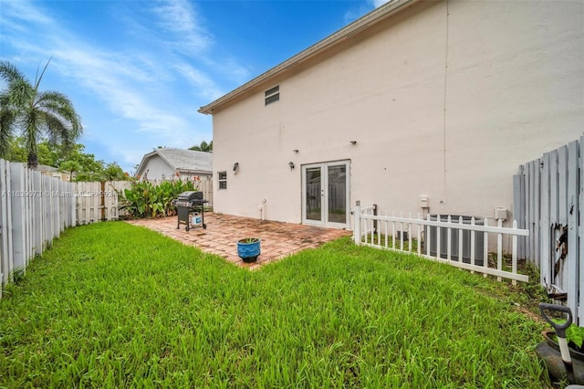 back of house with a lawn and a patio