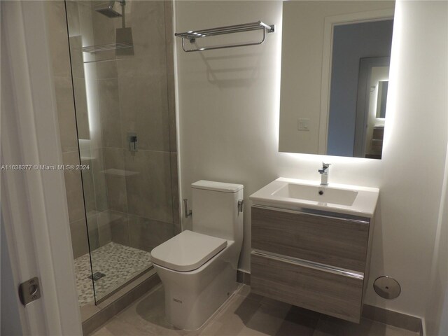 bathroom featuring toilet, vanity, a shower with shower door, and tile patterned flooring