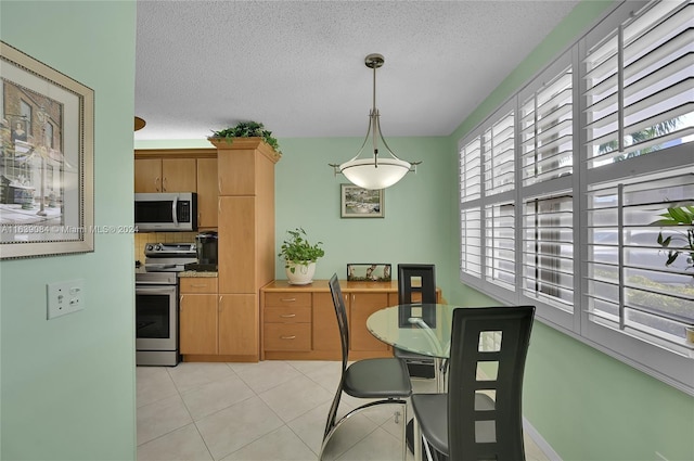 kitchen featuring tasteful backsplash, light tile patterned flooring, stove, and a wealth of natural light