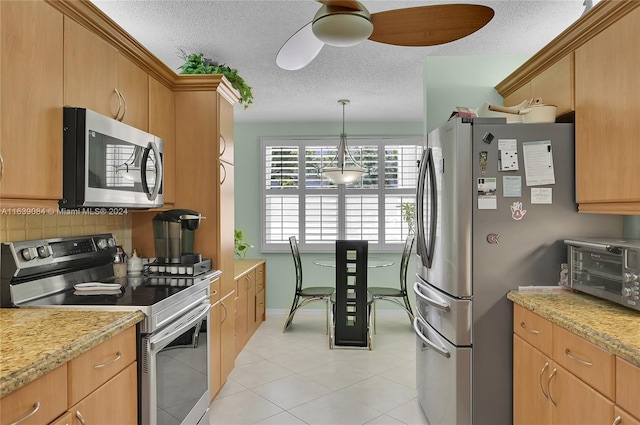 kitchen featuring appliances with stainless steel finishes, decorative light fixtures, light tile patterned floors, and light stone countertops