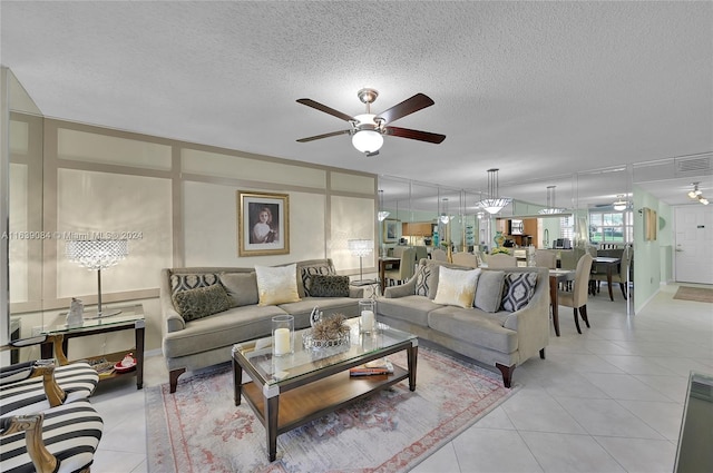 living room featuring a textured ceiling, light tile patterned flooring, and ceiling fan