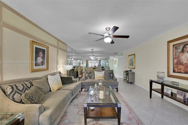 tiled living room with ceiling fan with notable chandelier, a textured ceiling, and ornamental molding