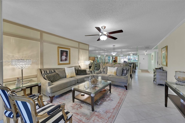 living room with light tile patterned floors, ceiling fan with notable chandelier, ornamental molding, and a textured ceiling