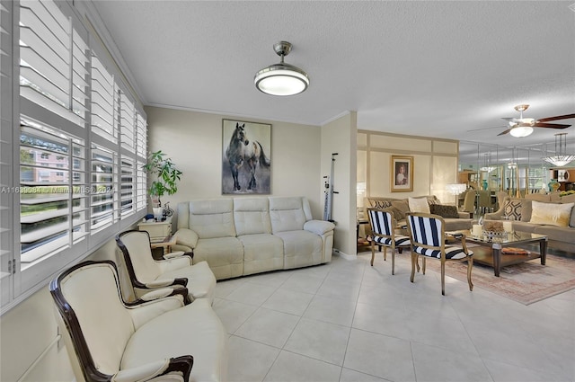 living area with a ceiling fan, ornamental molding, a textured ceiling, and tile patterned floors