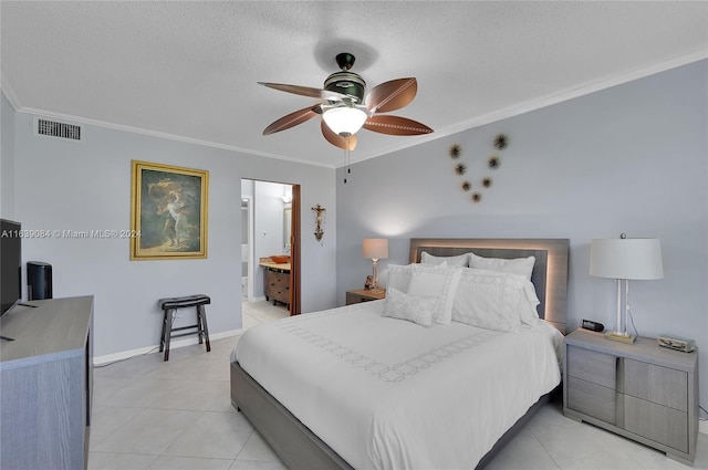 tiled bedroom featuring ensuite bath, ornamental molding, a textured ceiling, and ceiling fan