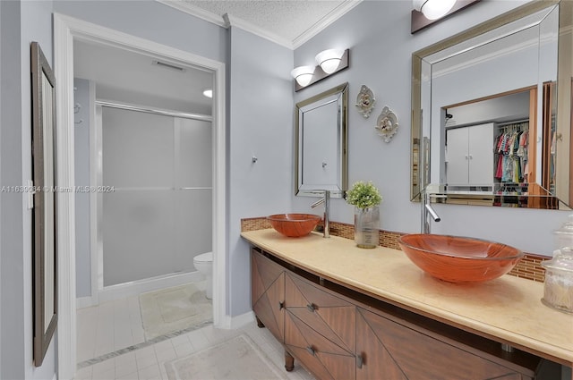 bathroom featuring double vanity, a textured ceiling, toilet, tile patterned floors, and ornamental molding