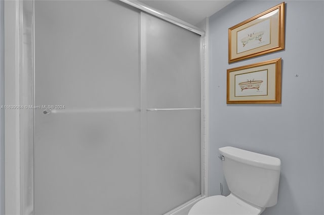 bathroom featuring walk in shower and toilet