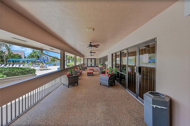 exterior space with an outdoor living space, ceiling fan, and a balcony