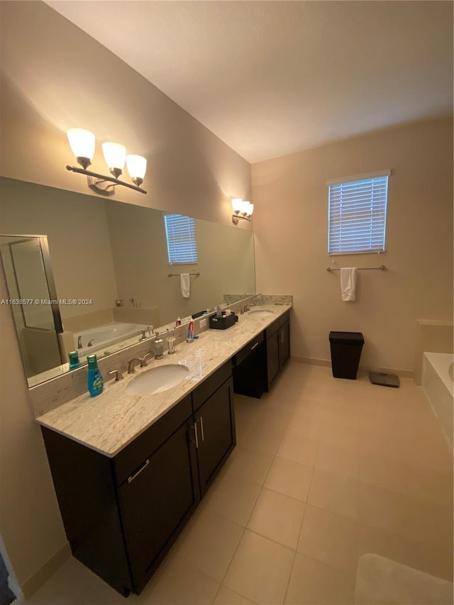 bathroom with a tub, dual vanity, tile patterned floors, and a chandelier