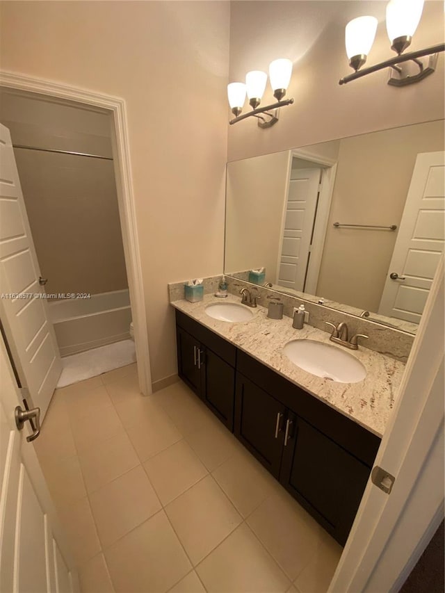 bathroom with a notable chandelier, double vanity, and tile patterned flooring