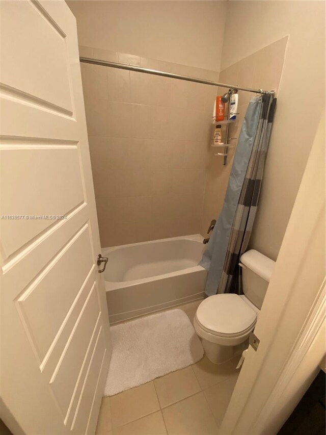 bathroom featuring shower / bath combo, tile patterned flooring, and toilet