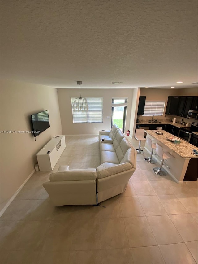 tiled living room featuring a textured ceiling and sink