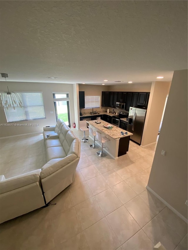 tiled living room featuring a textured ceiling and sink