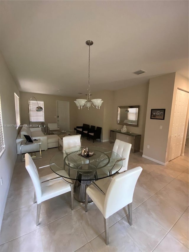 tiled dining space with a notable chandelier