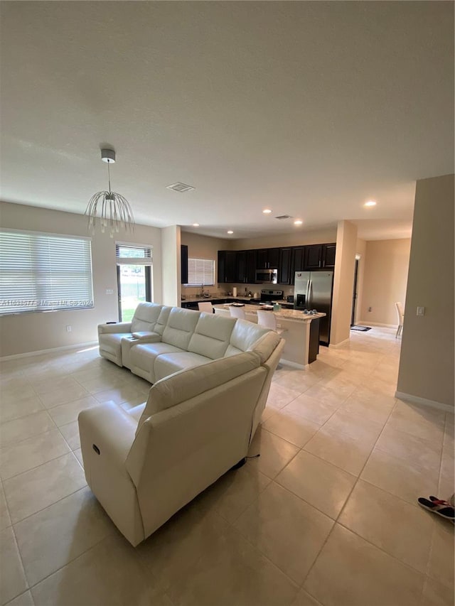 living room featuring light tile patterned floors and an inviting chandelier