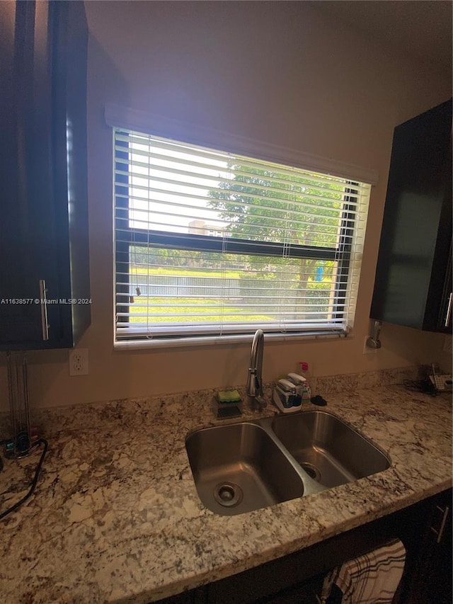 kitchen with light stone countertops and sink