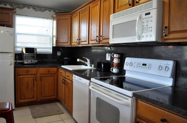 kitchen featuring light tile patterned floors, backsplash, sink, and white appliances