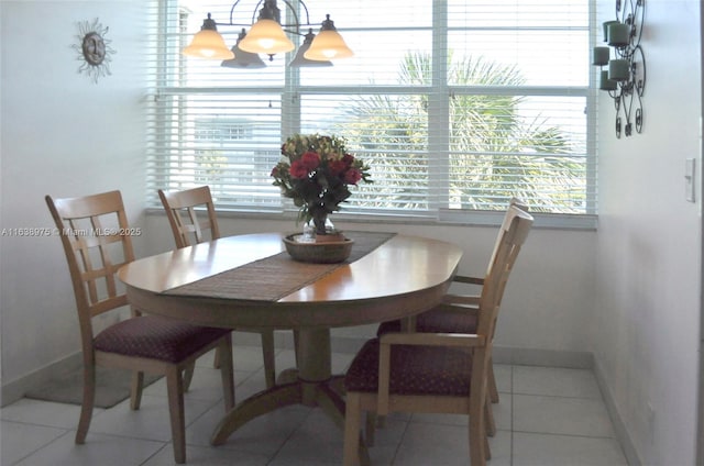 tiled dining area featuring an inviting chandelier and a healthy amount of sunlight