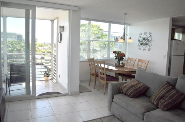 dining area featuring expansive windows, light tile patterned floors, and a chandelier