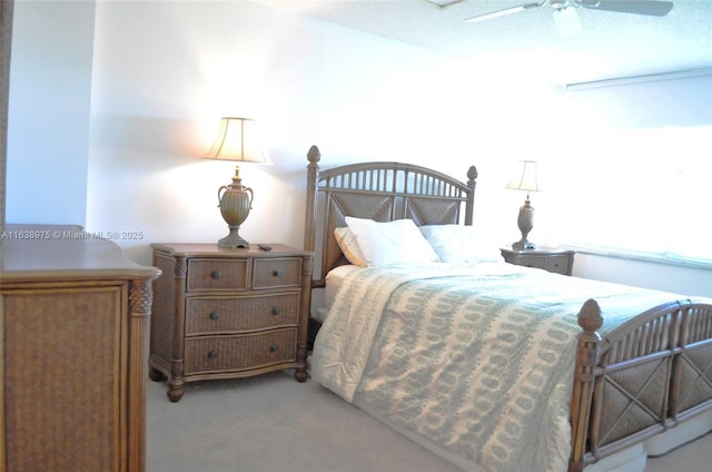 carpeted bedroom featuring ceiling fan and a textured ceiling