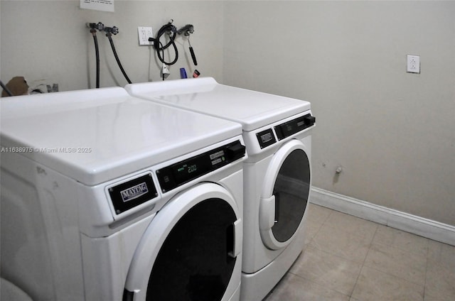 washroom with washer and clothes dryer and light tile patterned flooring