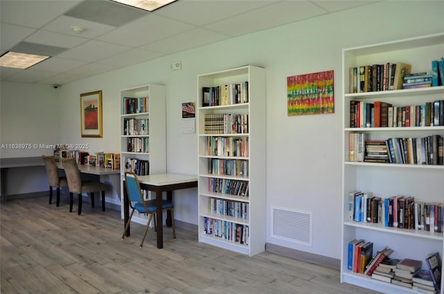 interior space featuring light wood-type flooring and a drop ceiling