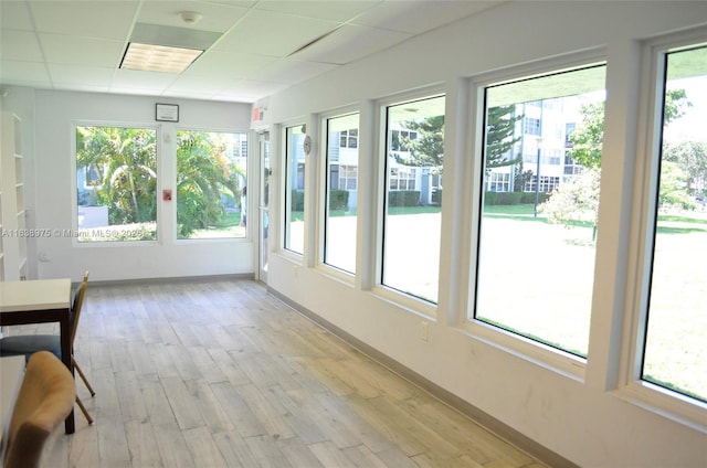 unfurnished sunroom with a paneled ceiling and plenty of natural light