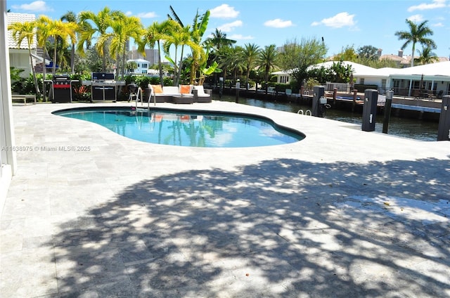 view of pool with a patio area and a water view