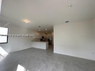 unfurnished living room with light tile patterned floors