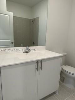 bathroom featuring tile patterned floors, vanity, and toilet