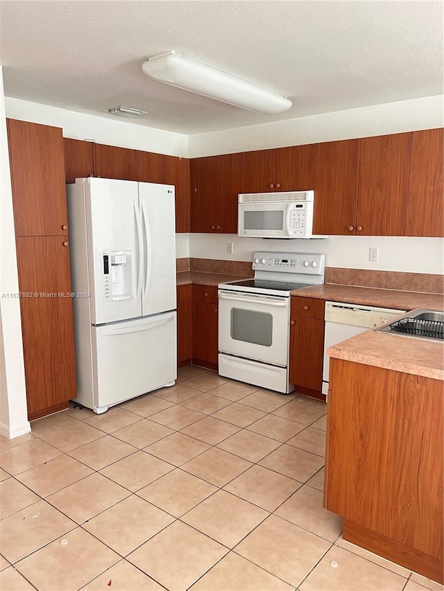 kitchen with light tile patterned floors and white appliances