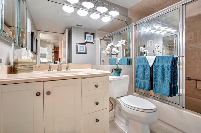 full bathroom with toilet, vanity, and shower / bath combination with glass door