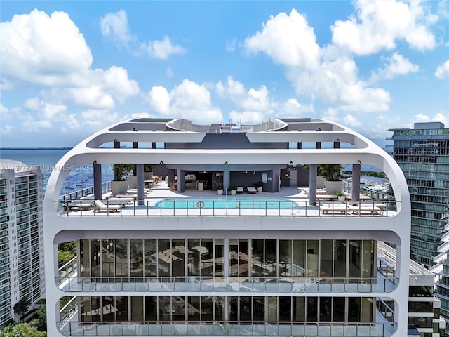exterior space with a community pool and a water view