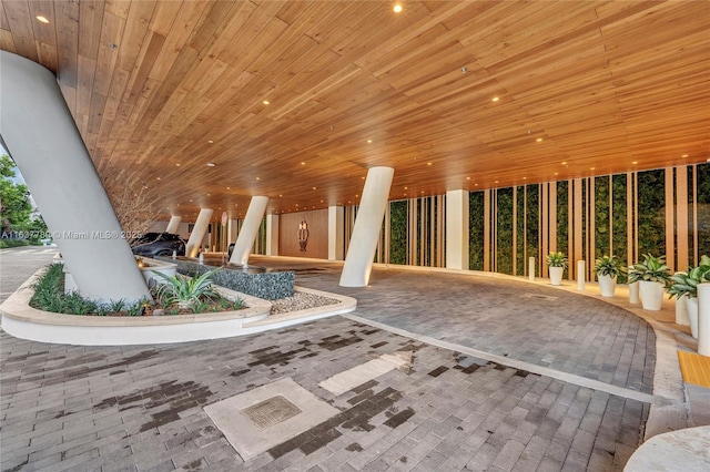 interior space with recessed lighting, wood ceiling, and brick floor