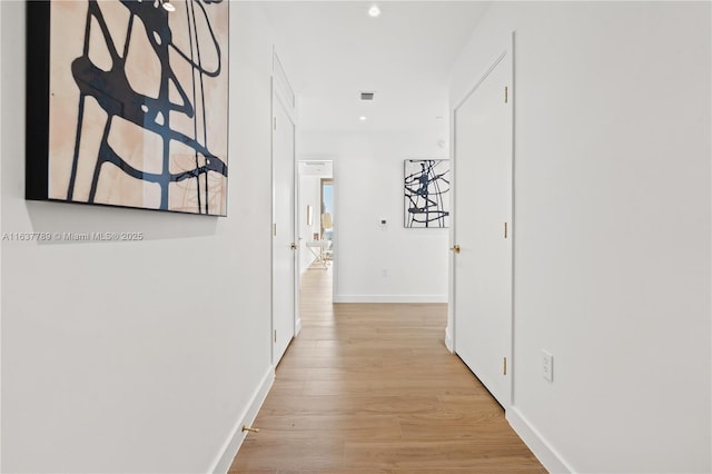 hall featuring recessed lighting, visible vents, baseboards, and light wood-style floors