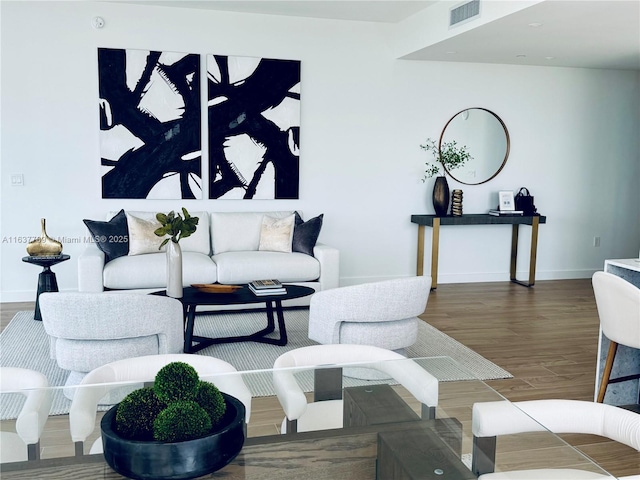 living room featuring wood finished floors, visible vents, and baseboards