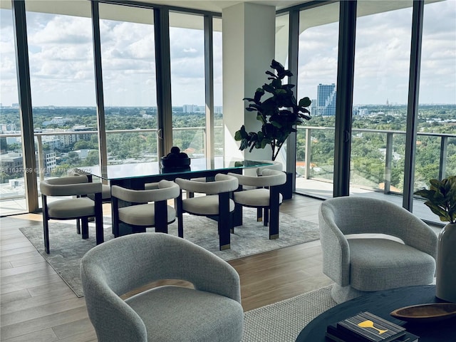 interior space featuring a wall of windows, a city view, and wood finished floors