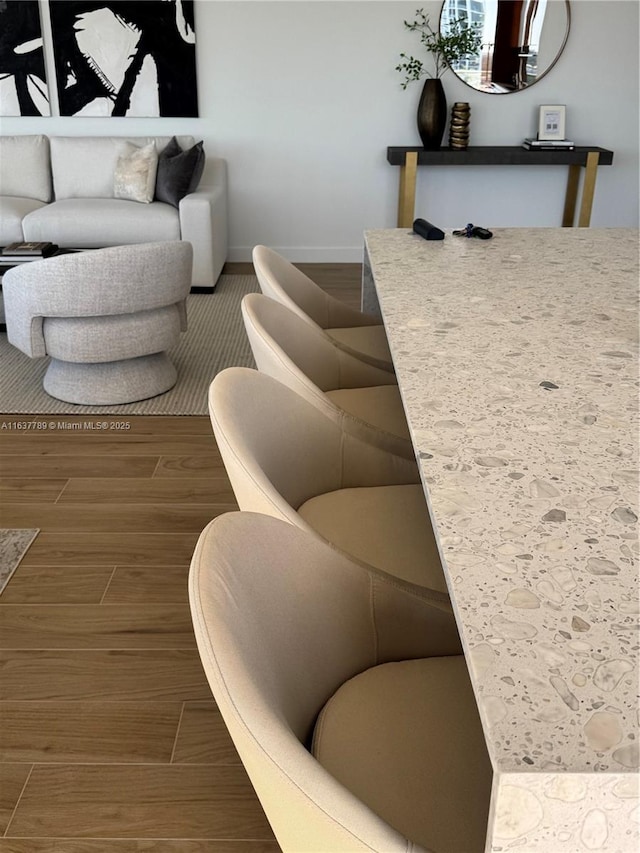 living area featuring baseboards and wood tiled floor