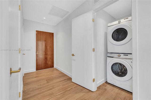 laundry room featuring light wood finished floors, visible vents, attic access, laundry area, and stacked washer / drying machine
