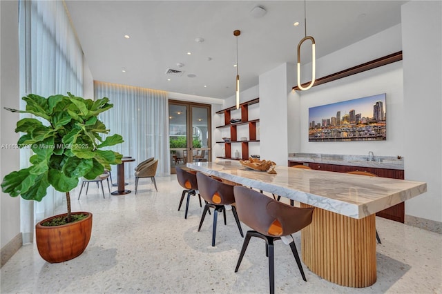 dining area with visible vents, baseboards, wet bar, recessed lighting, and light speckled floor