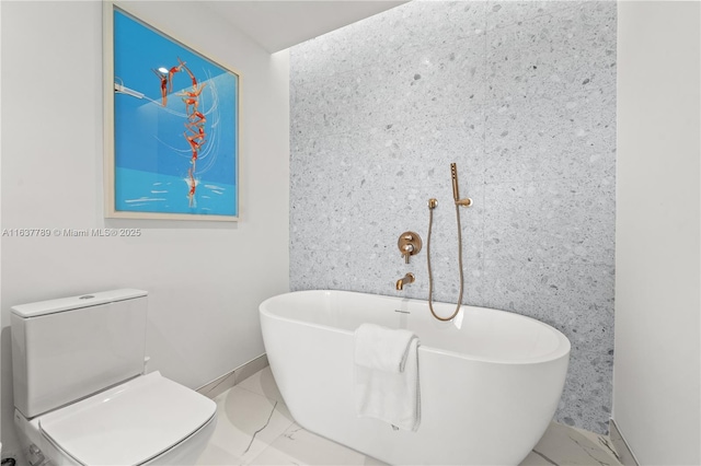 full bathroom featuring a soaking tub, marble finish floor, and toilet
