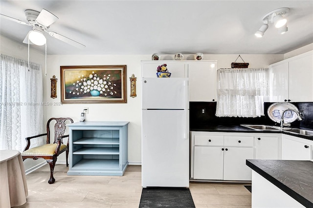 kitchen featuring sink, white cabinets, white fridge, and ceiling fan