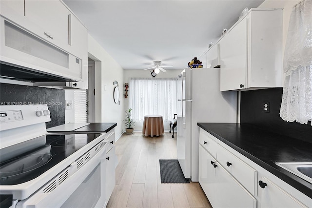 kitchen featuring white appliances, tasteful backsplash, and white cabinetry