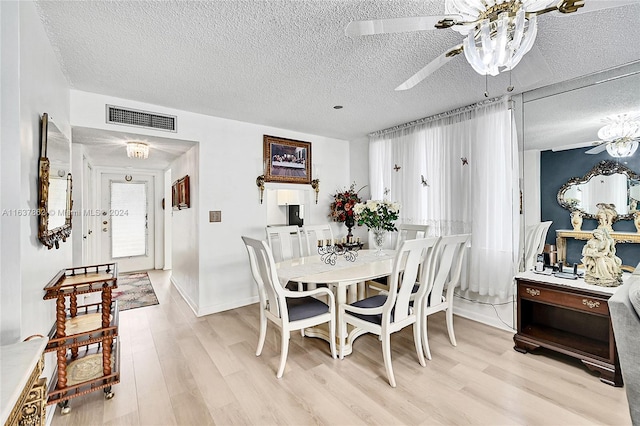 dining room with light hardwood / wood-style floors, a textured ceiling, and ceiling fan