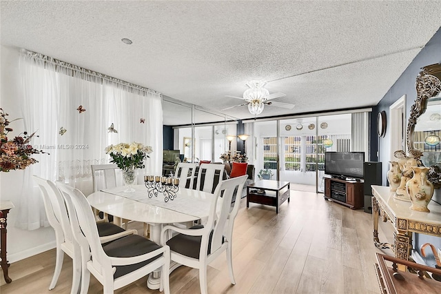 dining area featuring a textured ceiling, light wood-type flooring, and ceiling fan