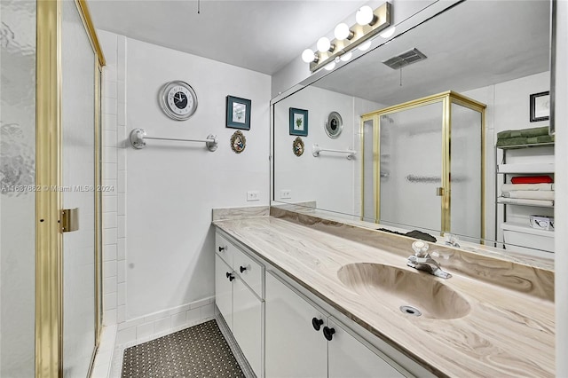 bathroom with vanity, an enclosed shower, and tile patterned floors