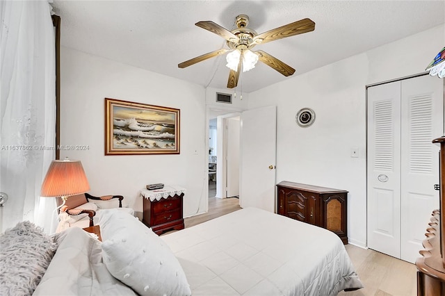 bedroom featuring a closet, light hardwood / wood-style floors, and ceiling fan