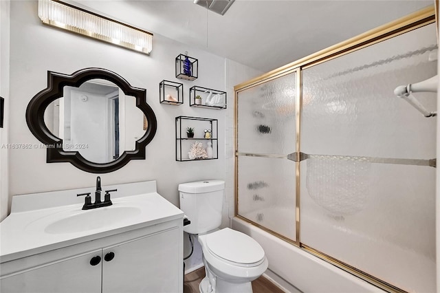 full bathroom with toilet, hardwood / wood-style floors, bath / shower combo with glass door, and vanity