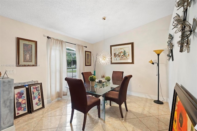 tiled dining space featuring vaulted ceiling and a textured ceiling