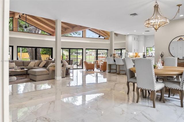 dining space with an inviting chandelier and high vaulted ceiling